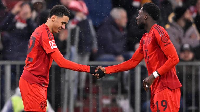 Bayern Münchens Jamal Musiala jubelt mit Alphonso Davies nach seinem Tor zum 4:2 gegen Heidenheim.