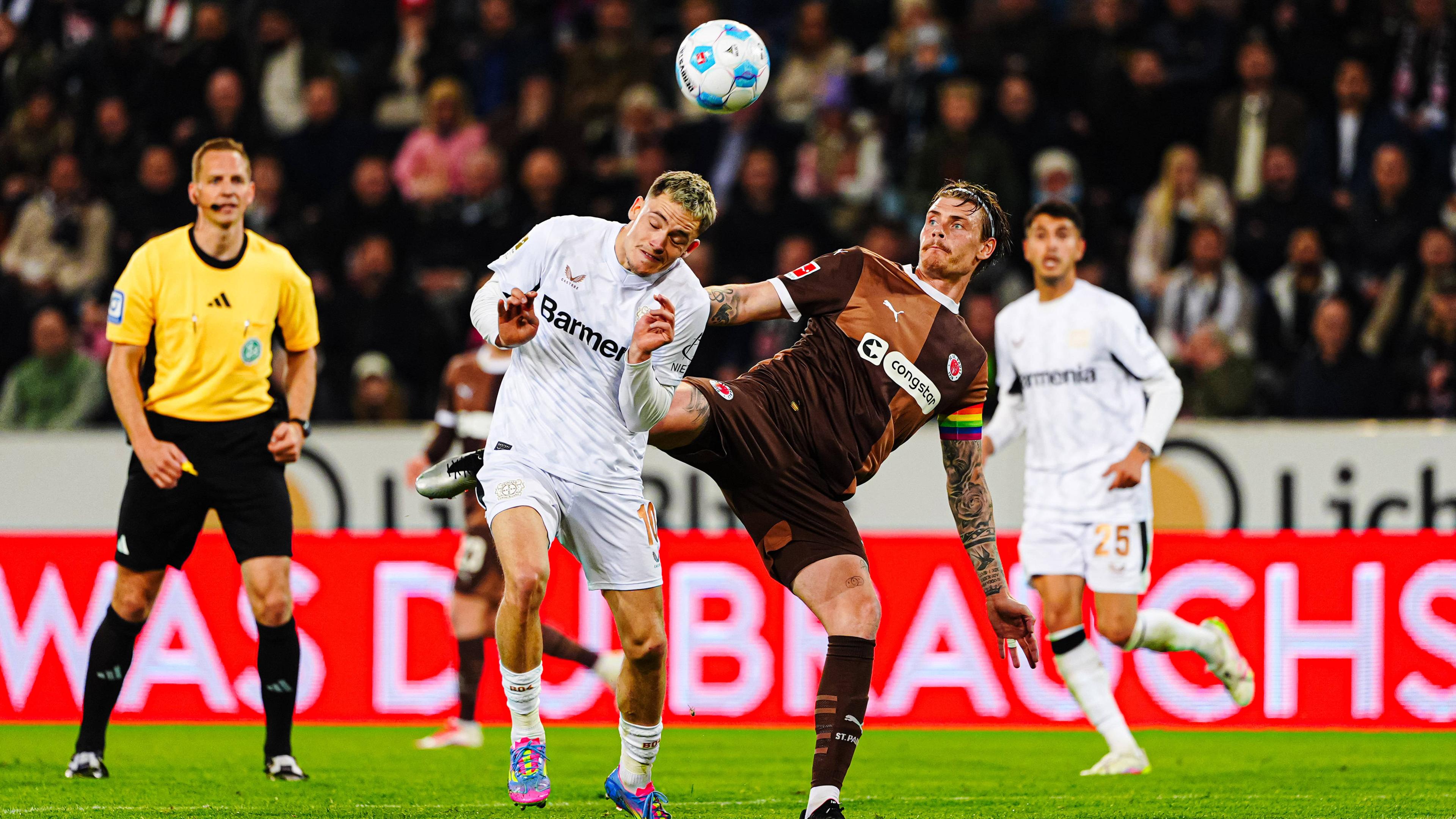 Leverkusens Florian Wirtz im Zweikampf um den Ball gegen St. Paulis Eric Smith.