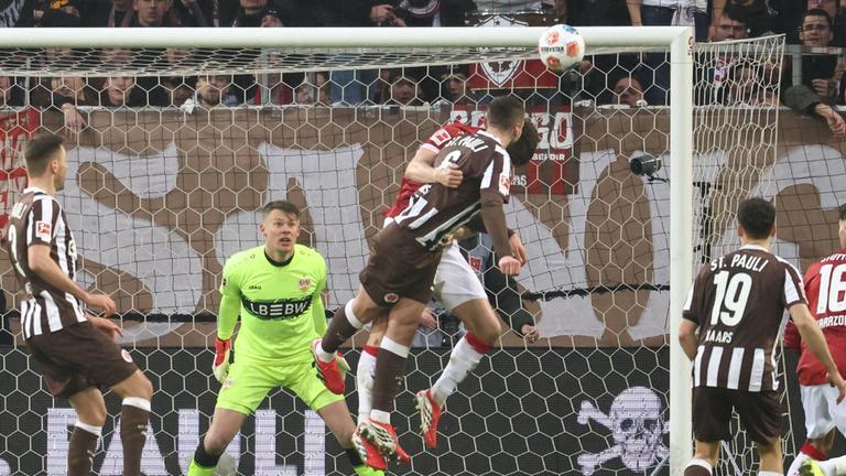 Stuttgarts niederländischer Verteidiger Ramon Hendriks (l.) und St. Paulis US-Mittelfeldspieler James Sands steigen zum Kopfball hoch während der Bundesliga-Partie zwischen dem FC St. Pauli und dem VfB Stuttgart.