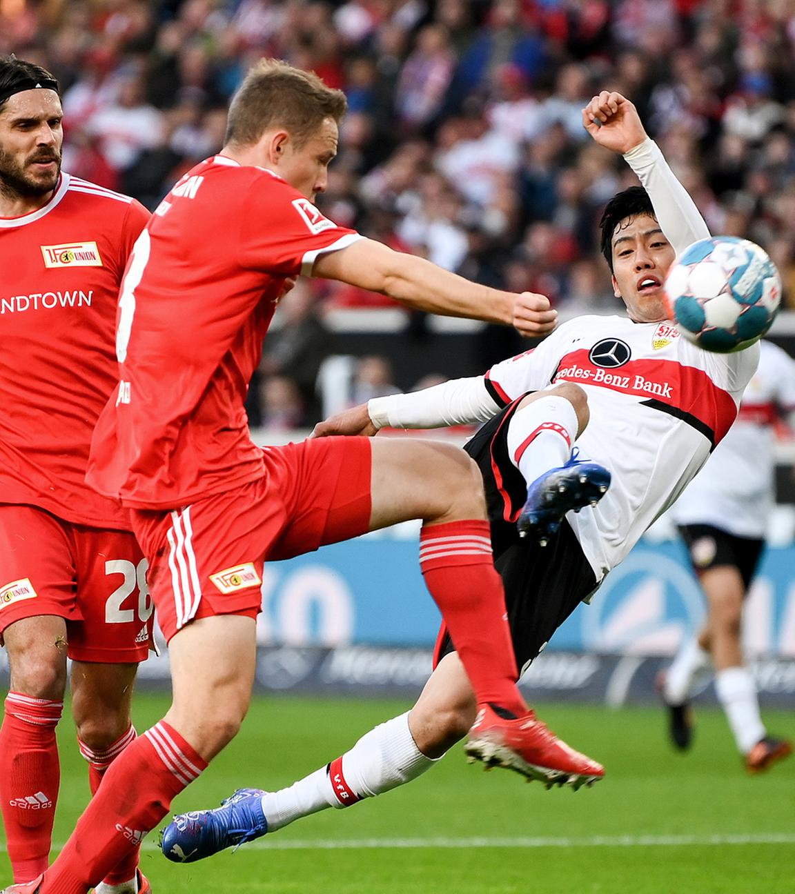 Stuttgarts Wataru Endo (r), Union Berlins Christopher Trimmel (l) und Paul Jaeckel (m) kämpfen um den Ball am 24.10.2021 in der Mercedes-Benz-Arena.