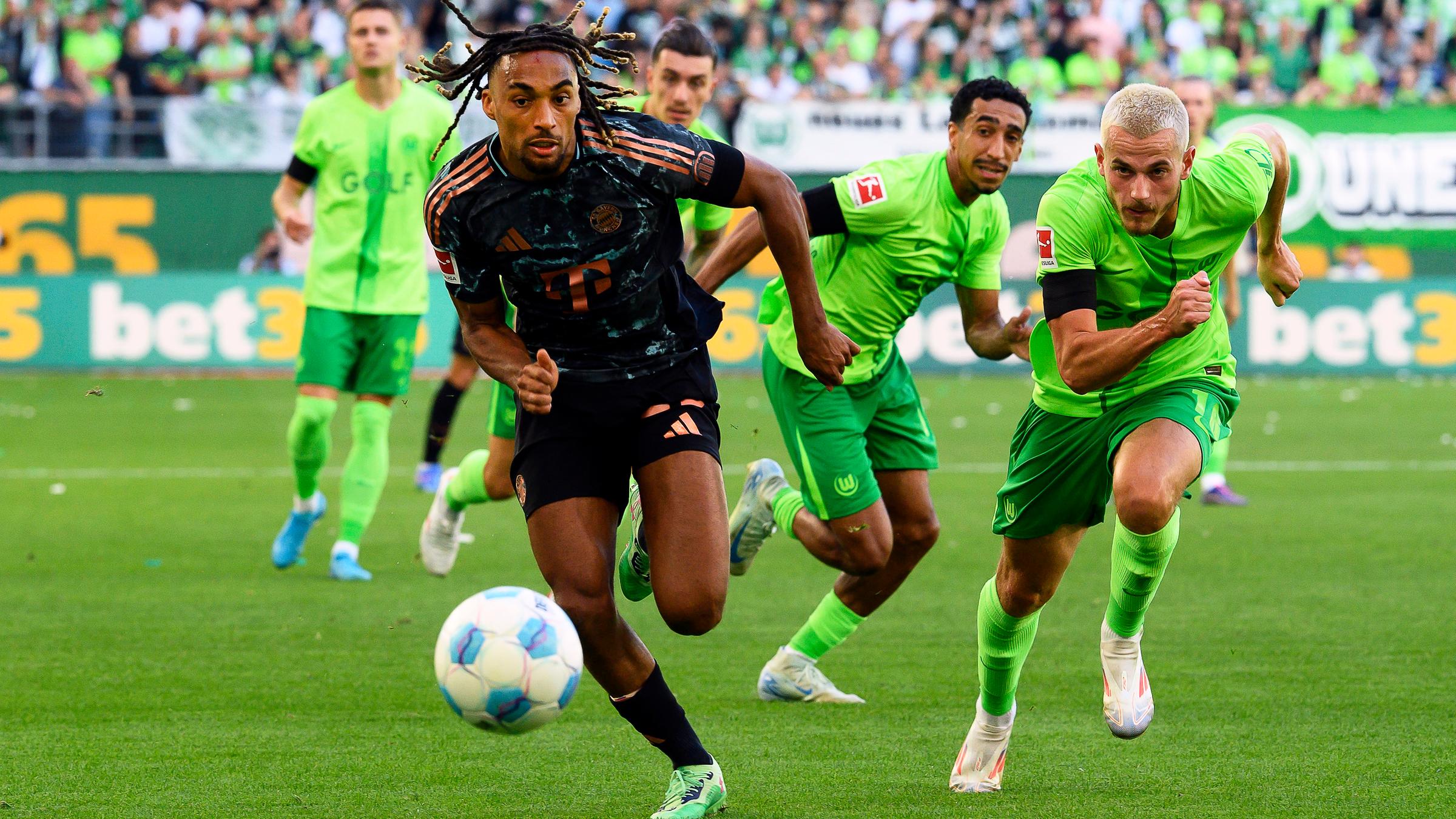 Bayern Münchens Sacha Boey in Aktion gegen Wolfsburgs Jakub Kaminski beim Auftaktspiel der Bundesliga.