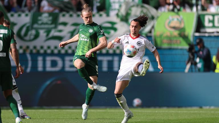 Patrick Wimmer (VfL Wolfsburg) und Arthur Theate (Eintracht Frankfurt) kämpfen um den Ball am 11.04.2026 in Wolfsburg.