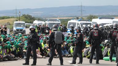 Thüringen, Erfurt: Polizisten umringen Demonstranten bei einer Sitzblockade auf Autobahn A71 nördlich des Erfurter Kreuzes bei Molsdorf.