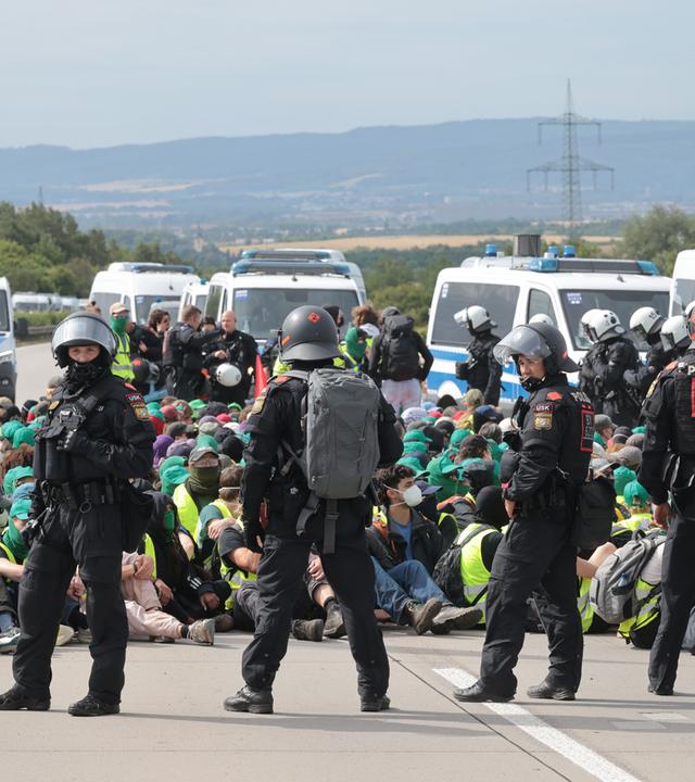 Thüringen, Erfurt: Polizisten umringen Demonstranten bei einer Sitzblockade auf Autobahn A71 nördlich des Erfurter Kreuzes bei Molsdorf.