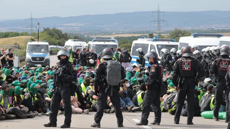 Thüringen, Erfurt: Polizisten umringen Demonstranten bei einer Sitzblockade auf Autobahn A71 nördlich des Erfurter Kreuzes bei Molsdorf.