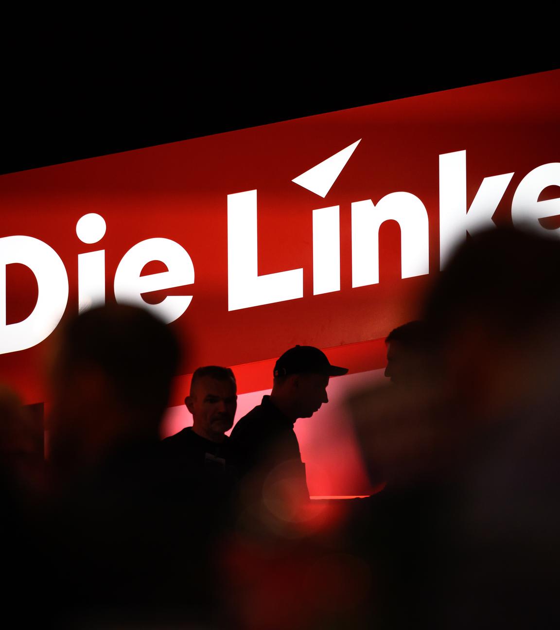 Delegierte sitzen auf dem Bundesparteitag unter dem Logo der Partei Die Linke in Chemnitz.