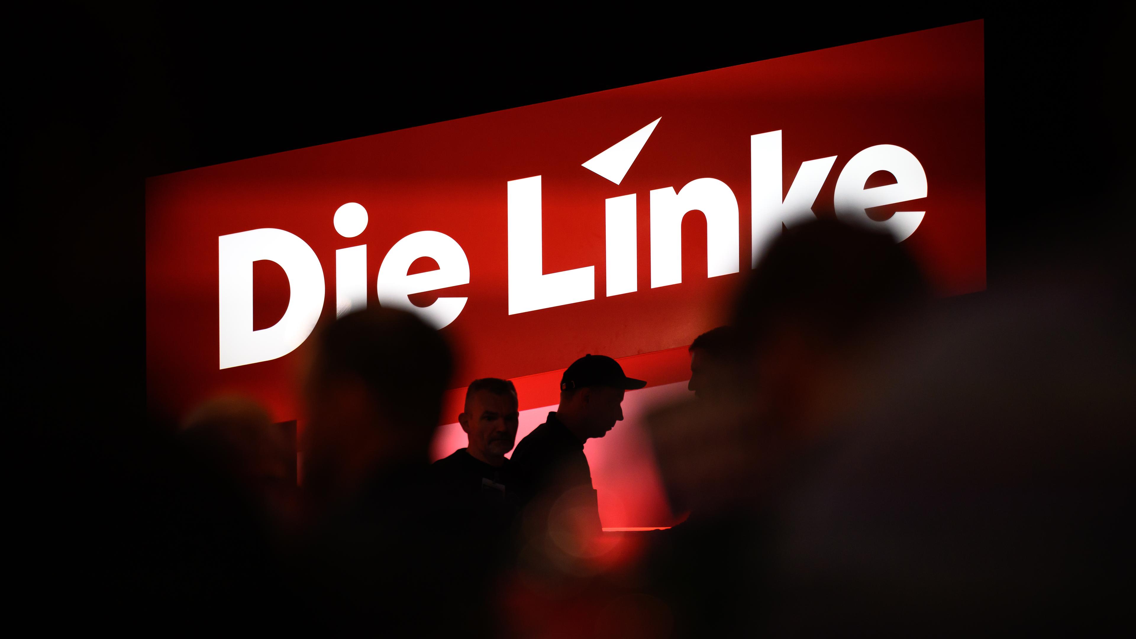 Delegierte sitzen auf dem Bundesparteitag unter dem Logo der Partei Die Linke in Chemnitz.