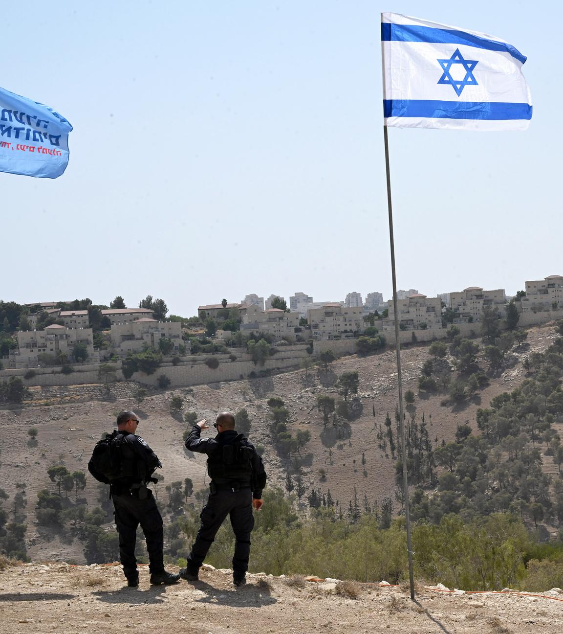 Israeli security waits for Israeli far-right Finance Minister Bezalel Smotrich to arrive for a press conference near Ma ale Adumim settlement, to announce his plan to approve more than 3,000 Jewish housing units, schools, health facilities and a country club in the controversarial E1 settlement project in the West Bank, on Thursday, August 14, 2025. 