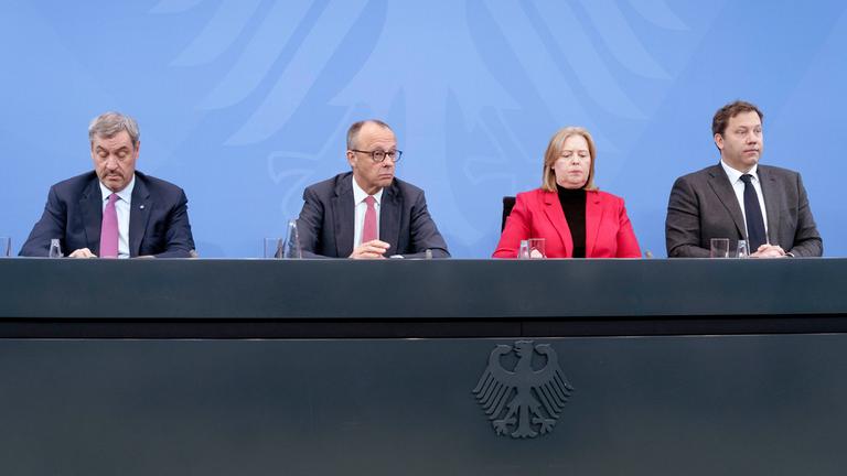 Markus Söder, Friedrich Merz, Bärbel Bas und Lars Klingbeil bei einem Pressestatment vor blauer Wand im Kanzleramt.