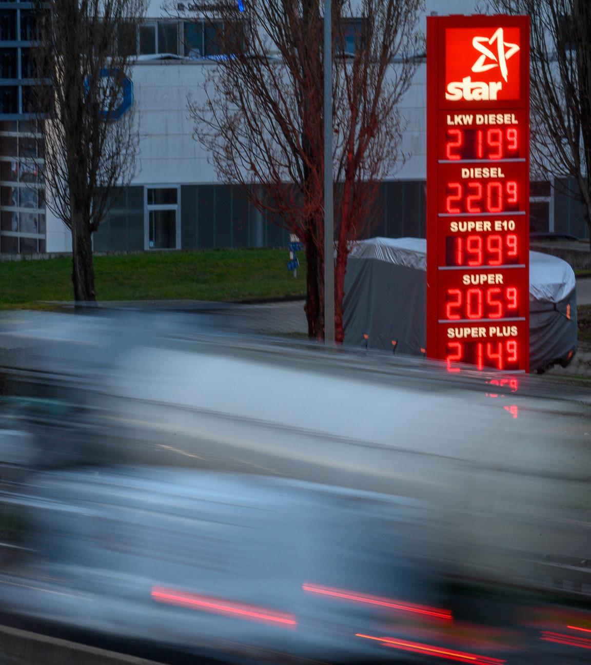 Sachsen-Anhalt, Magdeburg: Autos fahren am frühen Morgen im Stadtgebiet von Magdeburg an einer Preistafel einer Tankstelle vorbei.