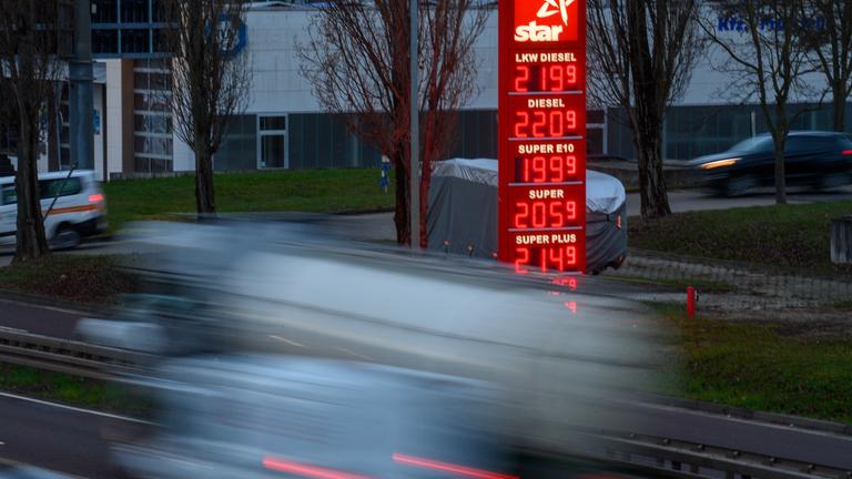 Sachsen-Anhalt, Magdeburg: Autos fahren am frühen Morgen im Stadtgebiet von Magdeburg an einer Preistafel einer Tankstelle vorbei.