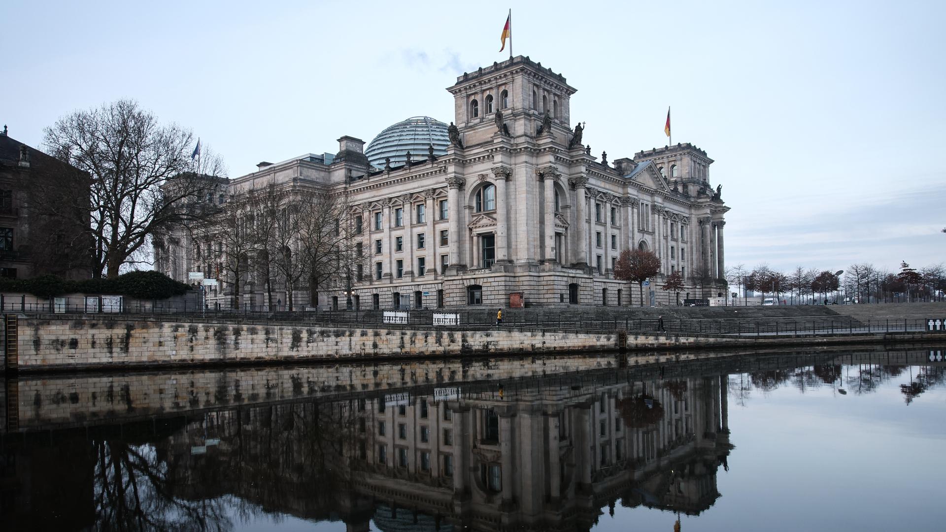 Das Reichstagsgebäude spiegelt sich in der Spree.