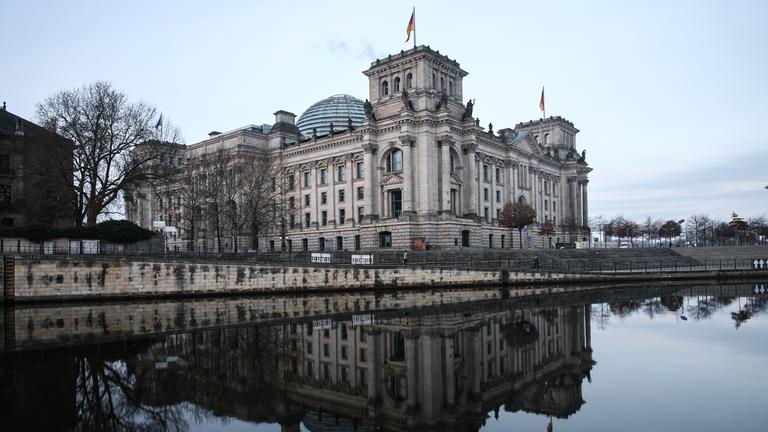 Das Reichstagsgebäude spiegelt sich in der Spree.
