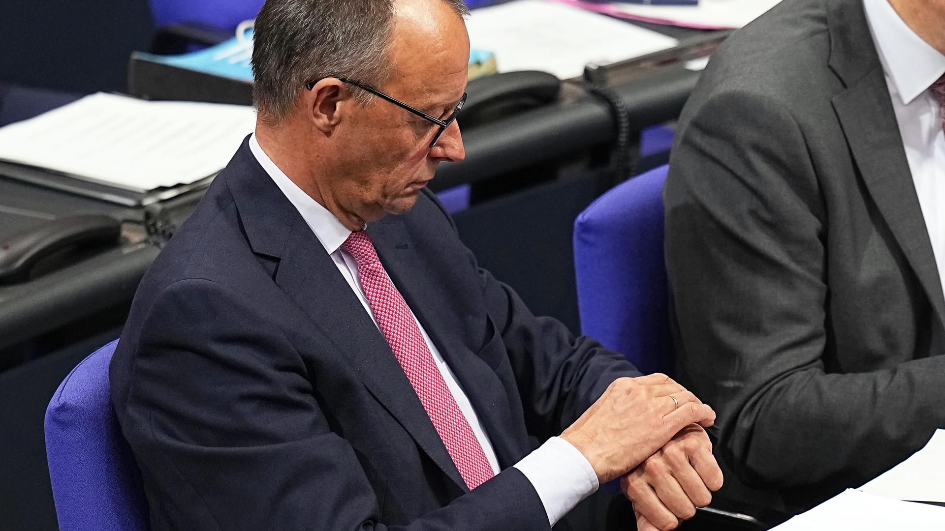 Berlin: Friedrich Merz, CDU-Bundesvorsitzender und CDU/CSU-Fraktionsvorsitzender im Bundestag, blickt nach der Abstimmung über das "Zustrombegrenzungsgesetz" der Union zur Eindämmung der Migration im Bundestag auf die Uhr.