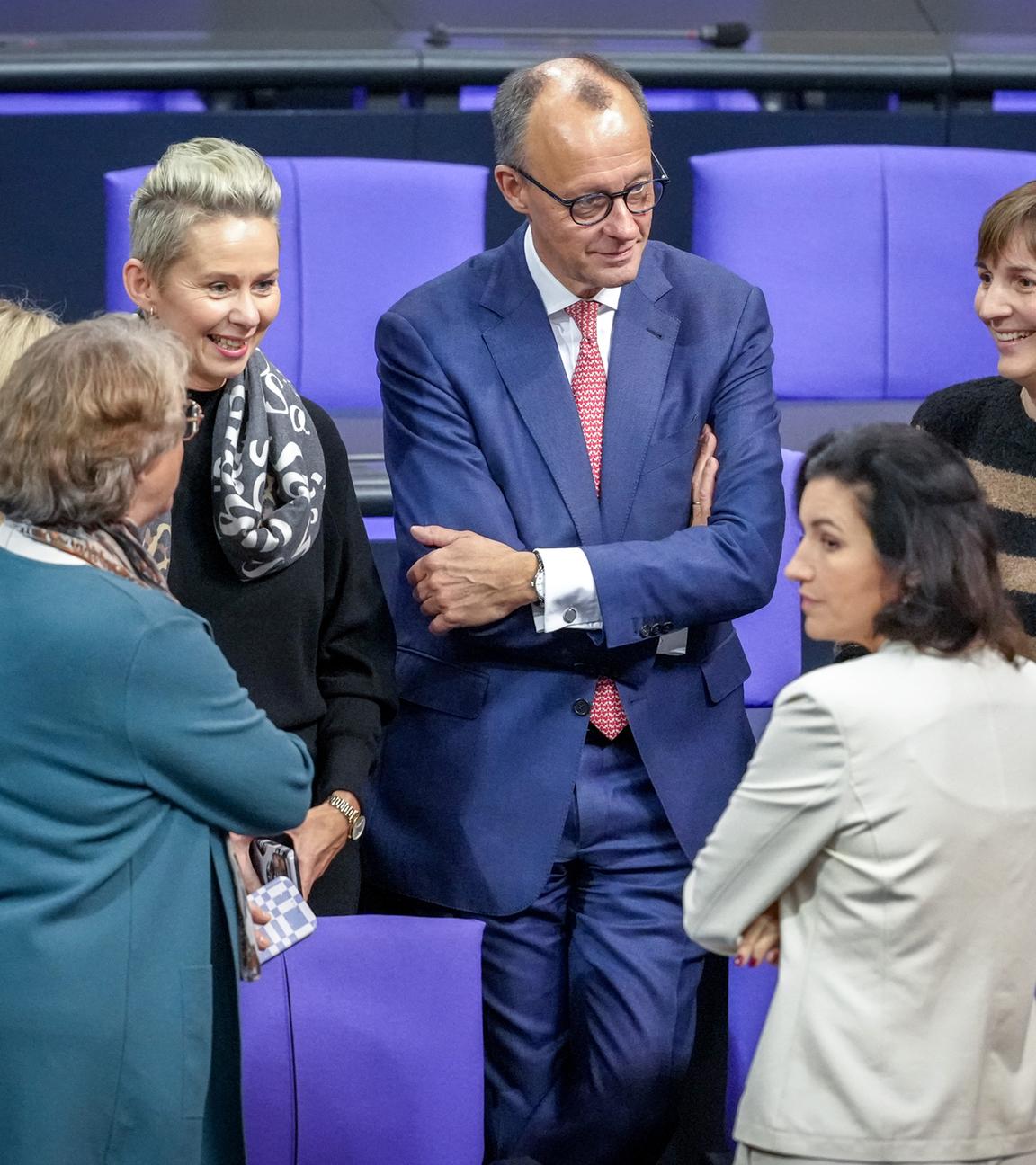 Berlin: Friedrich Merz (CDU,M), CDU-Bundesvorsitzender und Unionsfraktionsvorsitzender, steht im Plenum des Bundestags mit Abgeordneten der Unions-Fraktion zusammen.