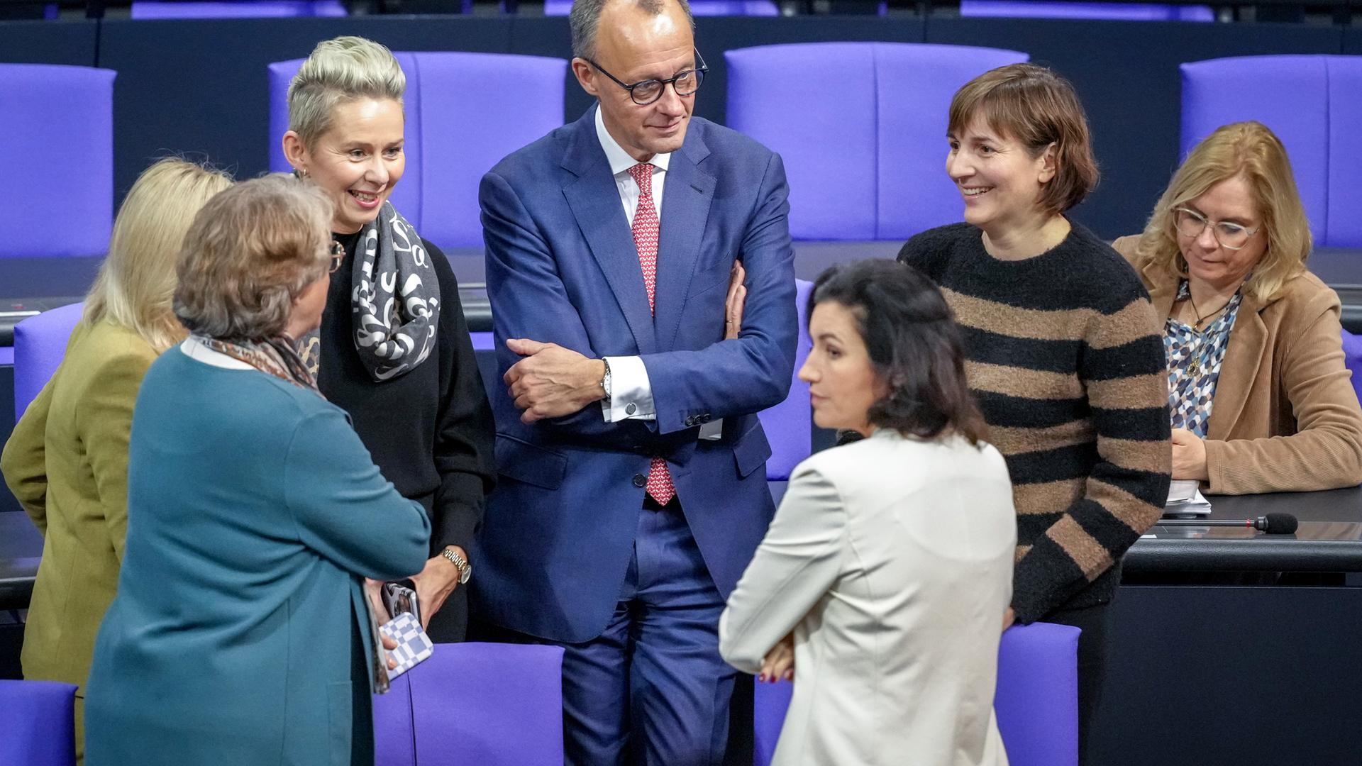 Berlin: Friedrich Merz (CDU,M), CDU-Bundesvorsitzender und Unionsfraktionsvorsitzender, steht im Plenum des Bundestags mit Abgeordneten der Unions-Fraktion zusammen.