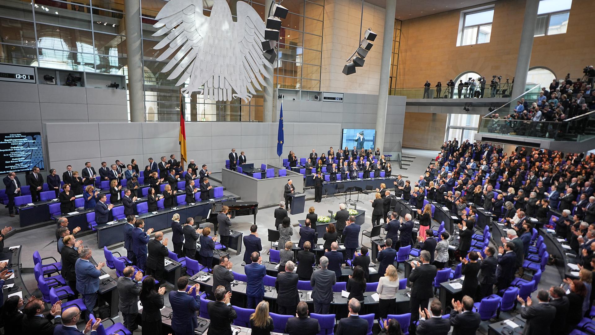 Archiv: Bundestag - Gedenkstunde für NS-Opfer: Roman Schwarzman, Holocaustüberlebender, steht am Rednerpult des Bundestages, während die Abgeordneten nach seiner Rede aufgestanden sind und applaudieren. 