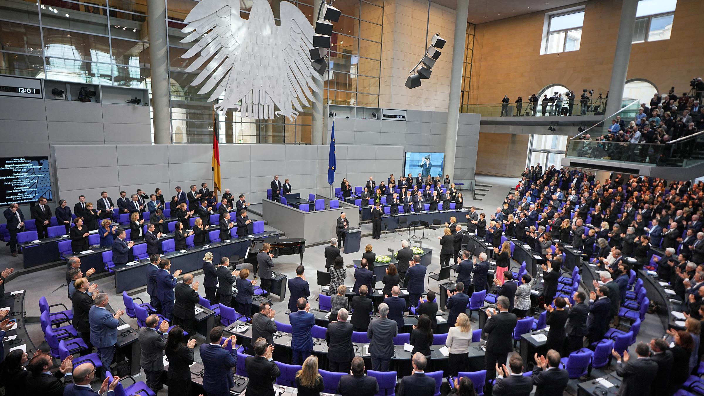 Archiv: Bundestag - Gedenkstunde für NS-Opfer: Roman Schwarzman, Holocaustüberlebender, steht am Rednerpult des Bundestages, während die Abgeordneten nach seiner Rede aufgestanden sind und applaudieren. 