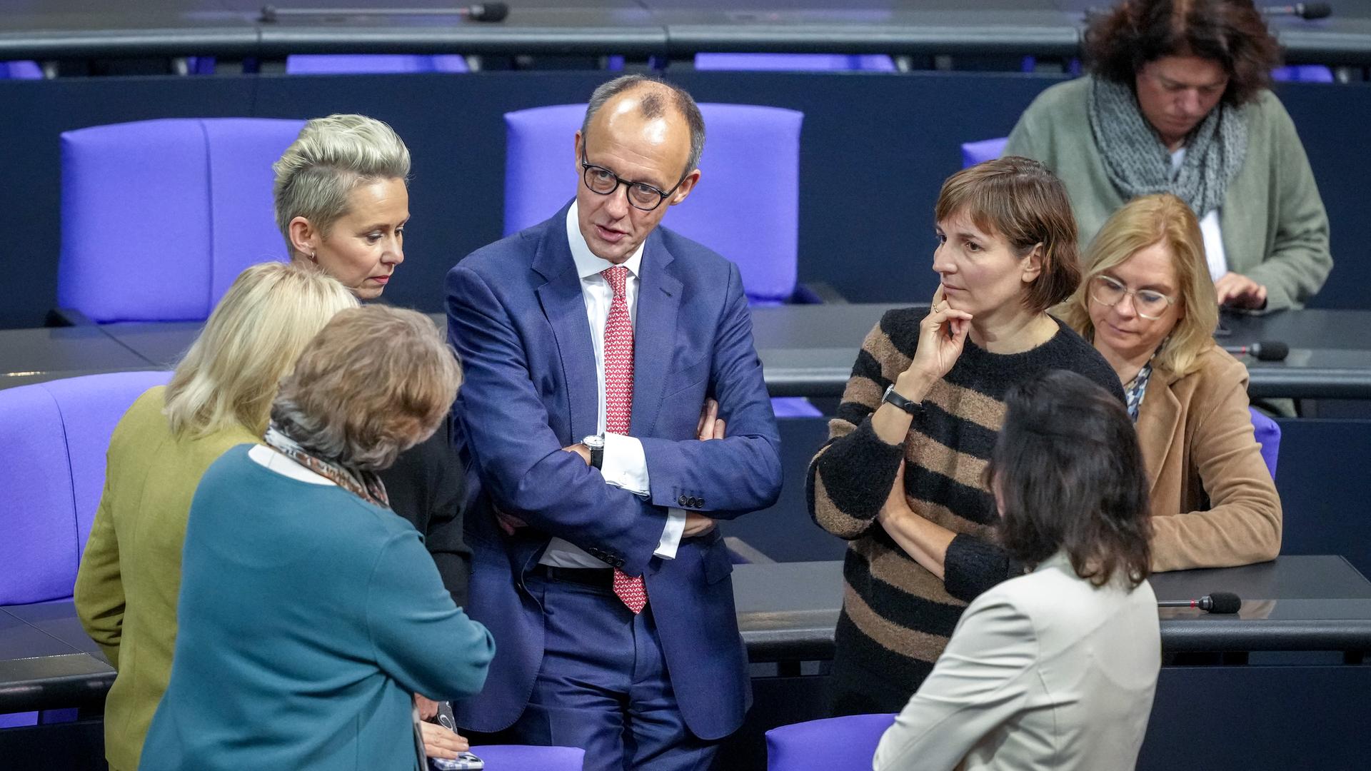  Berlin: Friedrich Merz (CDU, M), CDU-Bundesvorsitzender und Unionsfraktionsvorsitzender, steht im Plenum des Bundestags mit Abgeordneten der Unions-Fraktion zusammen.