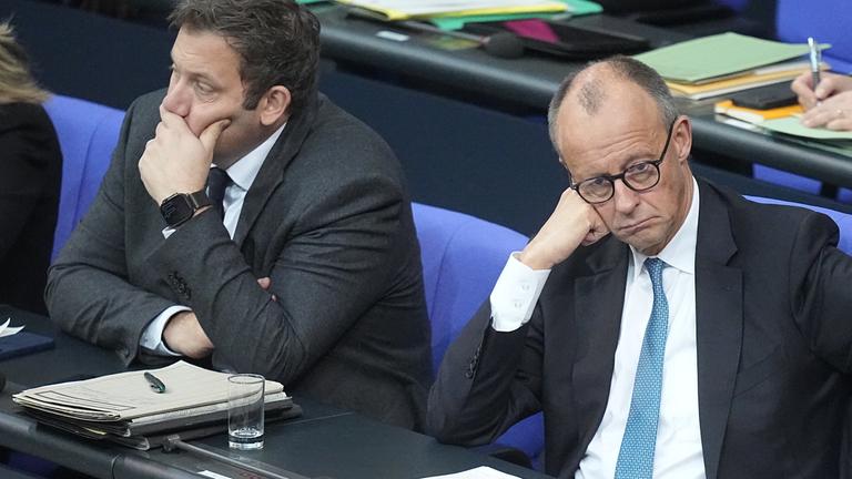 Bundesfinanzminister Lars Klingbeil (l, SPD) und Bundeskanzler Friedrich Merz (CDU) sitzen auf der Regierungsbank während der Generaldebatte im Bundestag.