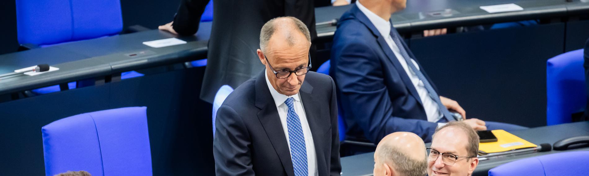 Berlin: Der designierte Bundeskanzler Friedrich Merz (CDU, M oben) und der geschäftsführende Bundeskanzler Olaf Scholz (SPD, unten M) schütteln sich neben Jens Spahn (CDU, l), Vorsitzender der CDU/CSU Bundestagsfraktion, und Alexander Dobrindt (CSU, r), designierter Innenminister, im Bundestag beim zweiten Durchgang der Kanzlerwahl die Hand.