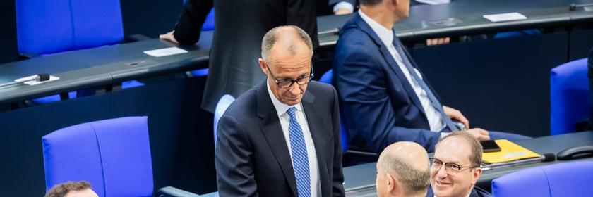 Berlin: Der designierte Bundeskanzler Friedrich Merz (CDU, M oben) und der geschäftsführende Bundeskanzler Olaf Scholz (SPD, unten M) schütteln sich neben Jens Spahn (CDU, l), Vorsitzender der CDU/CSU Bundestagsfraktion, und Alexander Dobrindt (CSU, r), designierter Innenminister, im Bundestag beim zweiten Durchgang der Kanzlerwahl die Hand.