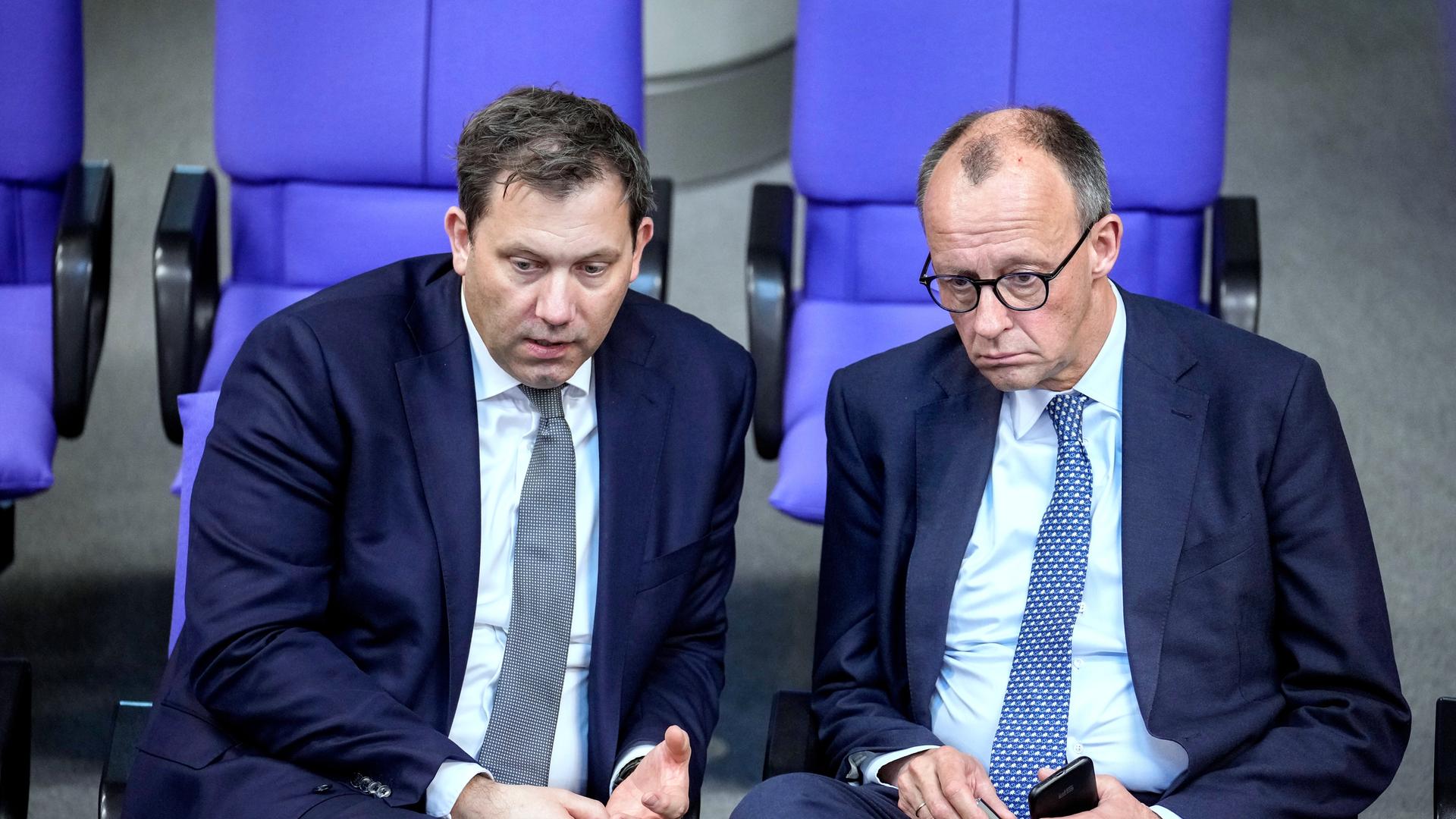 Friedrich Merz, leader of the Christian Democratic Union, right, and Social Democratic Party leader Lars Klingbeil talk during a meeting of the German federal parliament, Bundestag