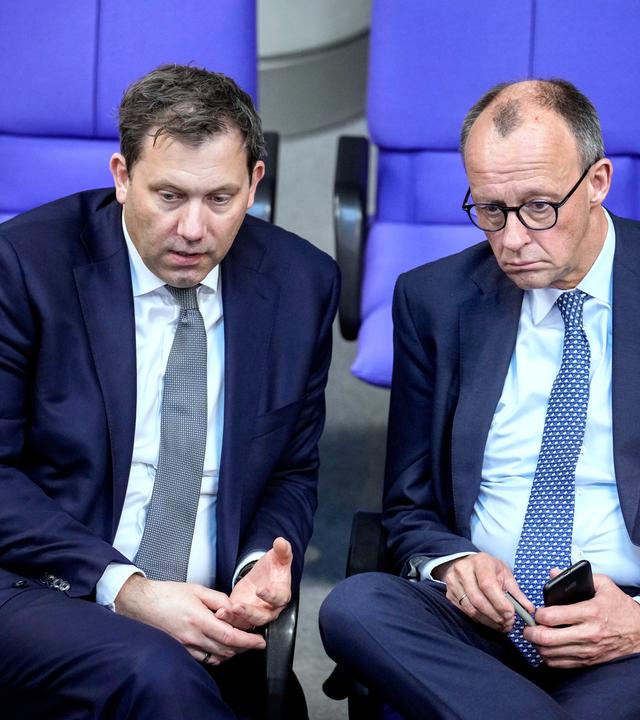 Friedrich Merz, leader of the Christian Democratic Union, right, and Social Democratic Party leader Lars Klingbeil talk during a meeting of the German federal parliament, Bundestag