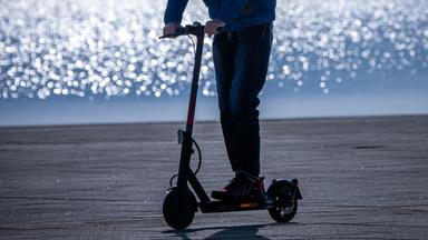 26.02.2025, Mecklenburg-Vorpommern, Rerik: Ein Fahrer ist mit einem Elektroroller am Hafen unterwegs.