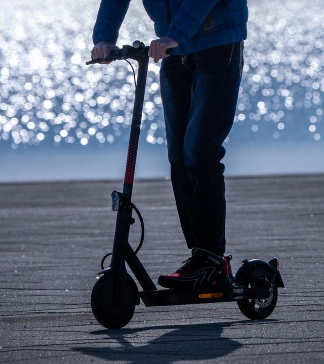 26.02.2025, Mecklenburg-Vorpommern, Rerik: Ein Fahrer ist mit einem Elektroroller am Hafen unterwegs.