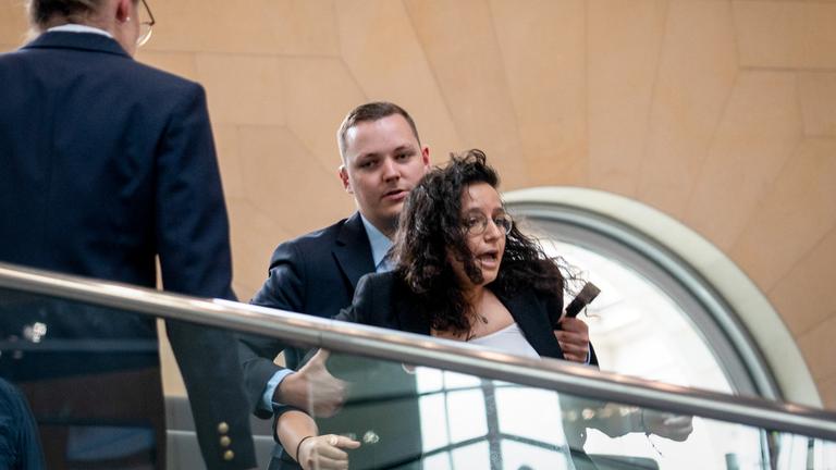 Eine Frau muss den Bundestag verlassen