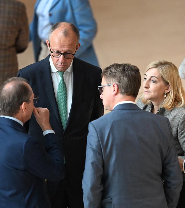 Bundeskanzler Friedrich Merz (CDU, in der M, r) unterhält sich mit Kabinettsmitgliedern nach der namentlichen Abstimmung zum Tankrabatt bzw. dem Energiesteuergesetz.