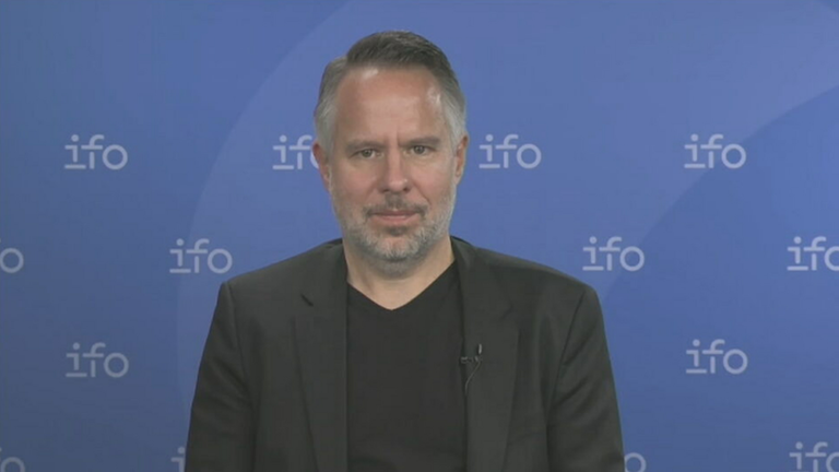 Prof. Dr. Andreas Peichl vom ifo-Institut ist zu sehen vor einer ifo-Werbewand.