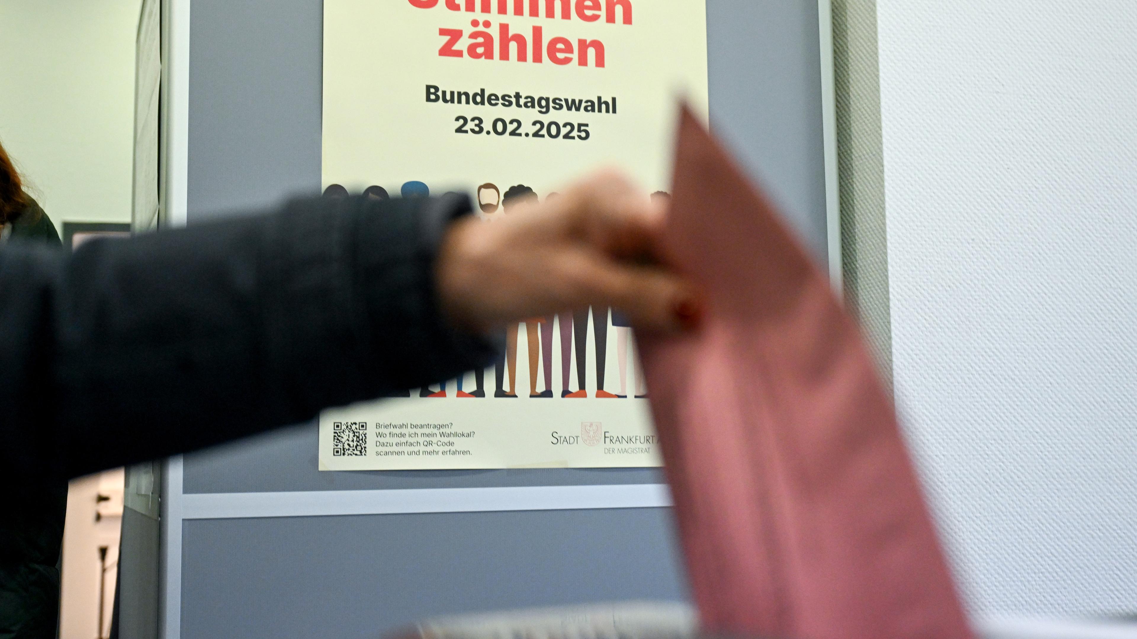 Eine Frau wirft im Briefwahllokal vor dem Plakat «Alle Stimmen zählen» ihren Briefwahlumschlag nach ihrer frühzeitigen Stimmabgabe zur Bundestagswahl in die Wahlurne.