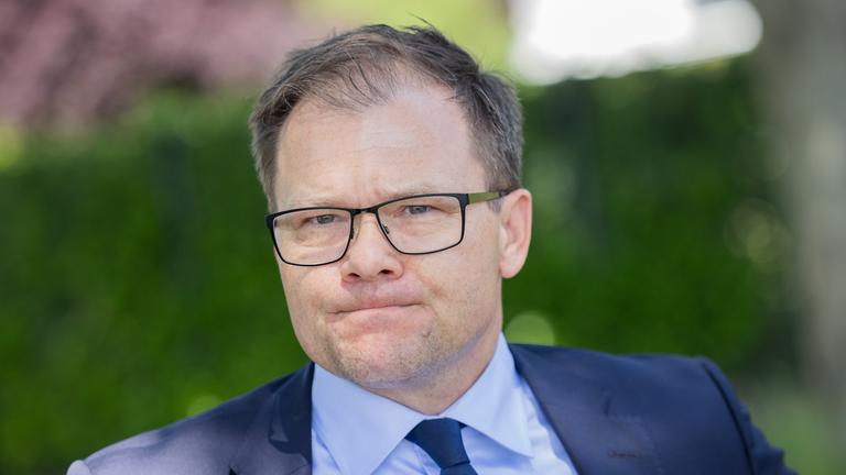 Bundesumweltminister Carsten Schneider (SPD) steht bei Trockenheit und Niedrigwasser am Rhein bei Bonn. 