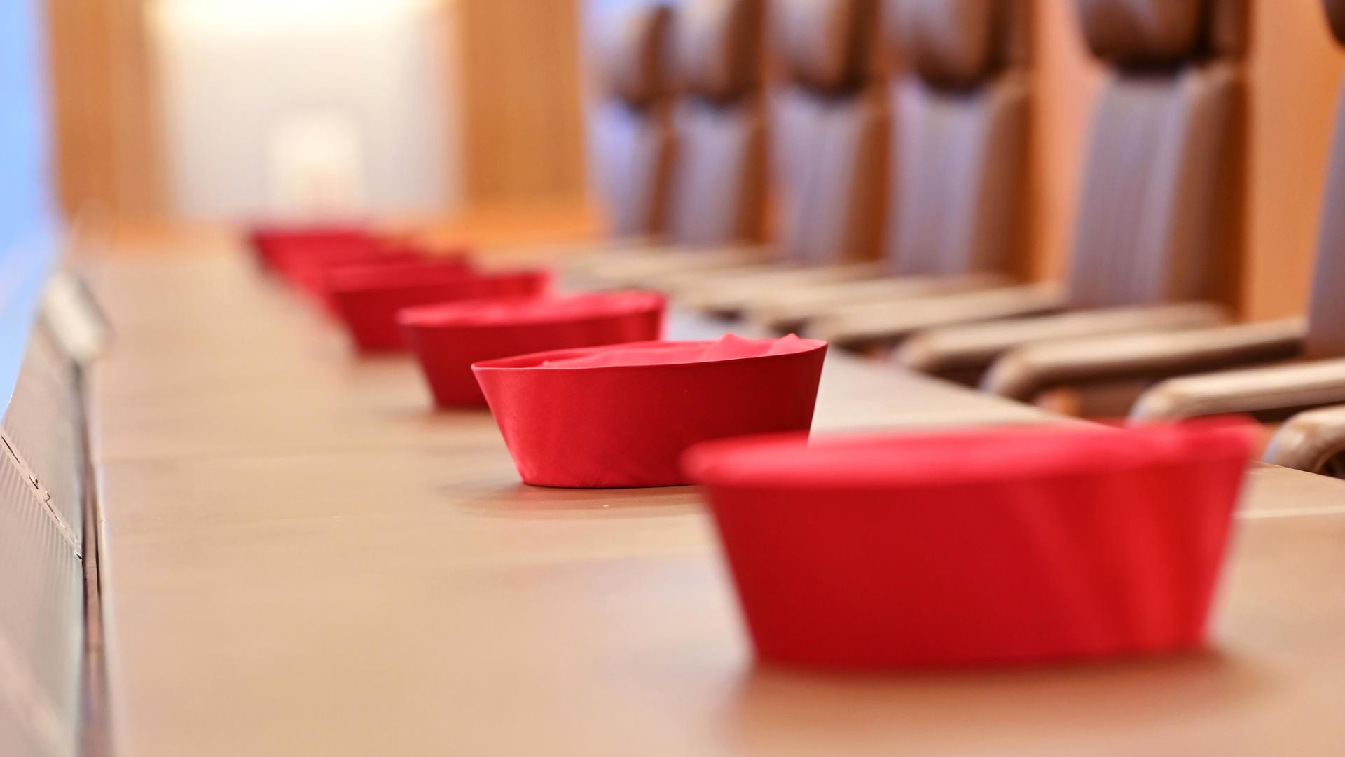 Auf der Richterbank im Sitzungssaal im Bundesverfassungsgericht liegen Barette der Bundesverfassungsrichter des ersten Senats, aufgenommen am 30.08.2021