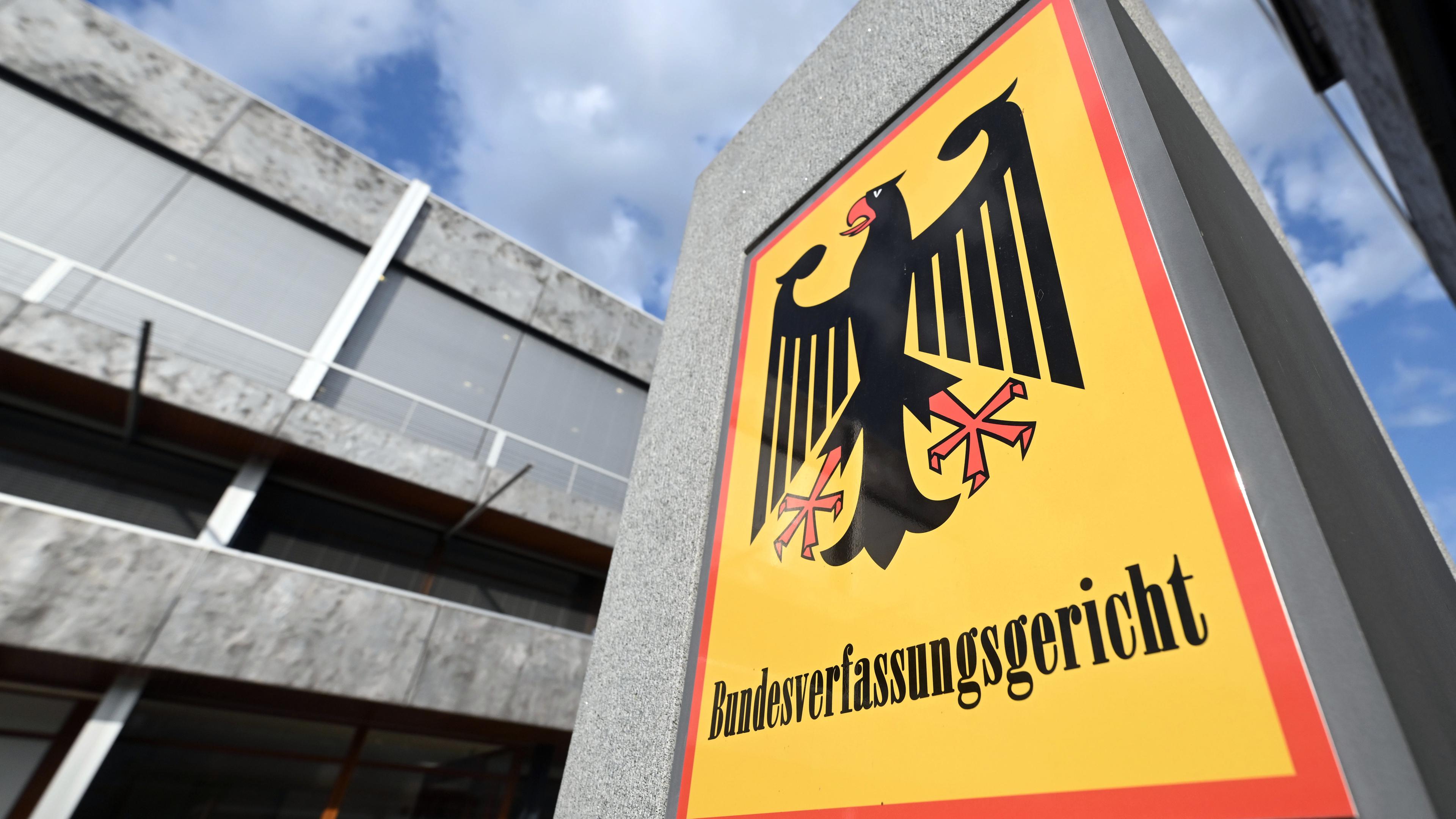 Symbolbild:  Ein Schild mit Bundesadler und dem Schriftzug Bundesverfassungsgericht, aufgenommen vor dem Gericht.