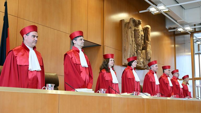 Der Erste Senat des Bundesverfassungsgericht, (l-r) Günter Spinner, Martin Eifert, Ines Härtel, Yvonne Ott, Stephan Harbarth, Vorsitzender des Senats und Präsident des Gerichts, Henning Radtke, Heinrich Amadeus Wolff, Miriam Meßling, eröffnet die mündliche Verhandlung zum Bayerischen Polizeiaufgabengesetz am 07.07.2026 in Karlsruhe.