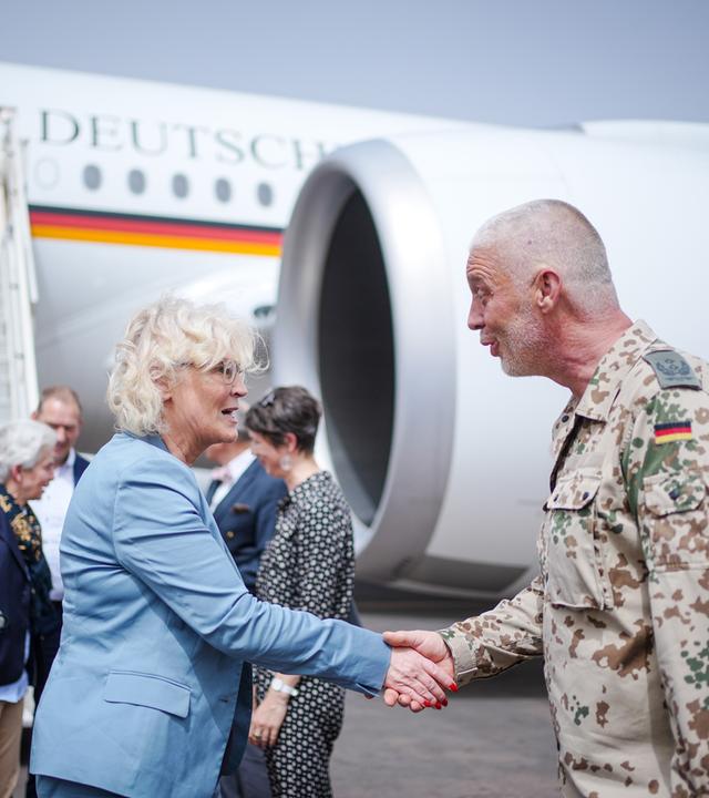 Bundesverteidigungsministerin Christine Lambrecht schütelt die Hand eines Bundeswehr-Soldaten. Sie stehen vor einem Flugzeug. Mali.
