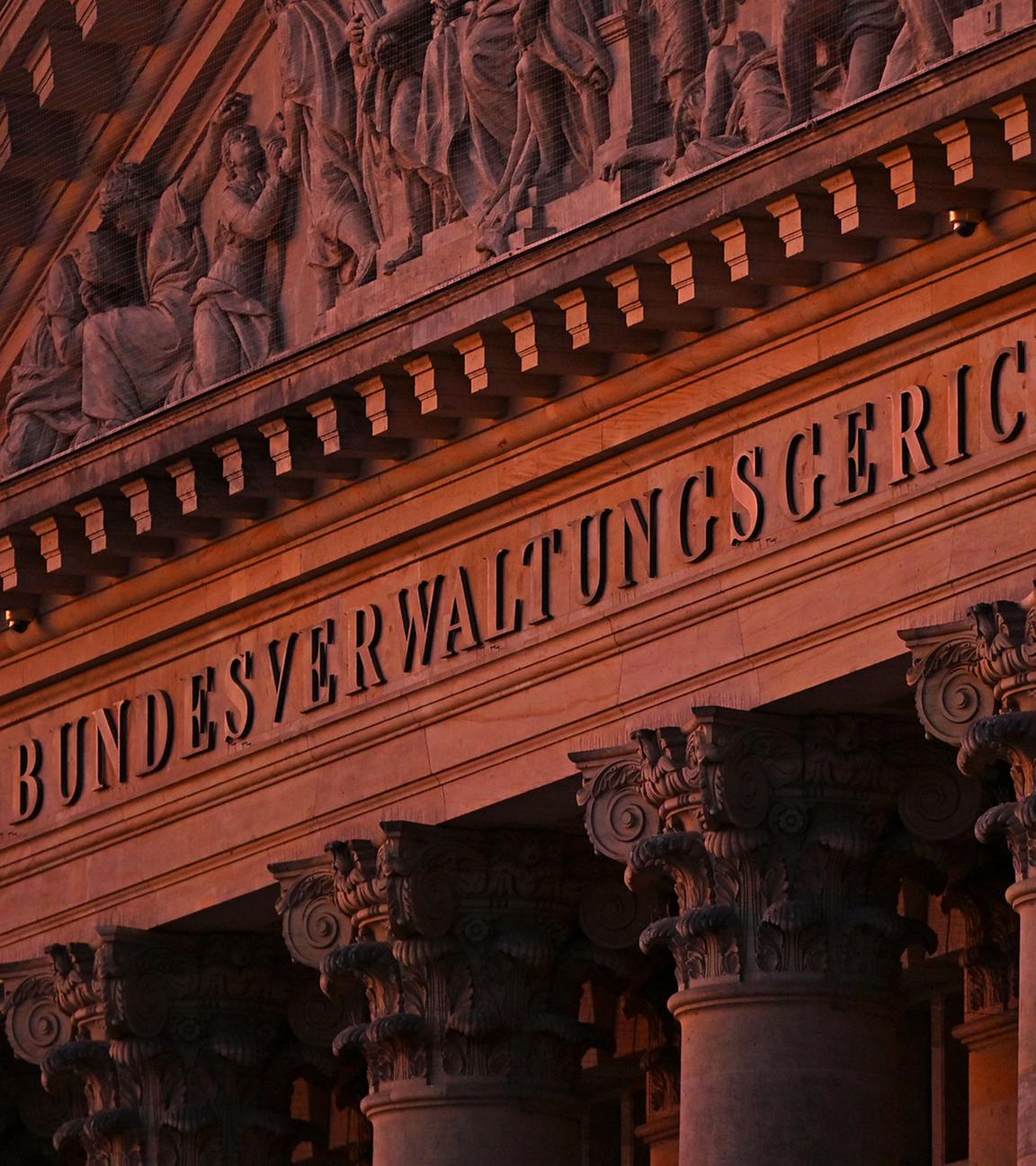 Blick auf den Dreiecksgiebel der Hauptfassade des Bundesverwaltungsgerichts Leipzig in der Morgendämmerung.