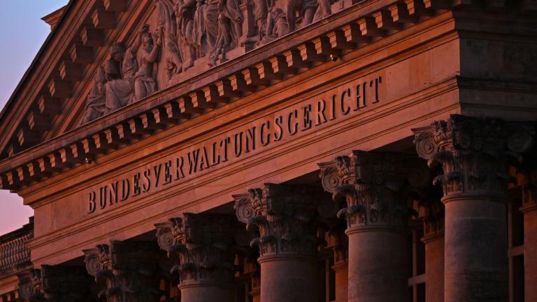 Blick auf den Dreiecksgiebel der Hauptfassade des Bundesverwaltungsgerichts Leipzig in der Morgendämmerung.