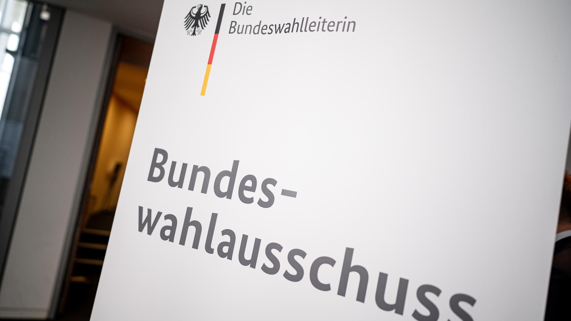 Schild mit Aufschrift: 'Die Bundeswahlleiterin - Bundeswahlausschuss'.