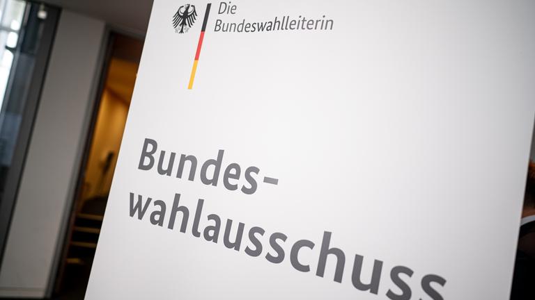 Schild mit Aufschrift: 'Die Bundeswahlleiterin - Bundeswahlausschuss'.