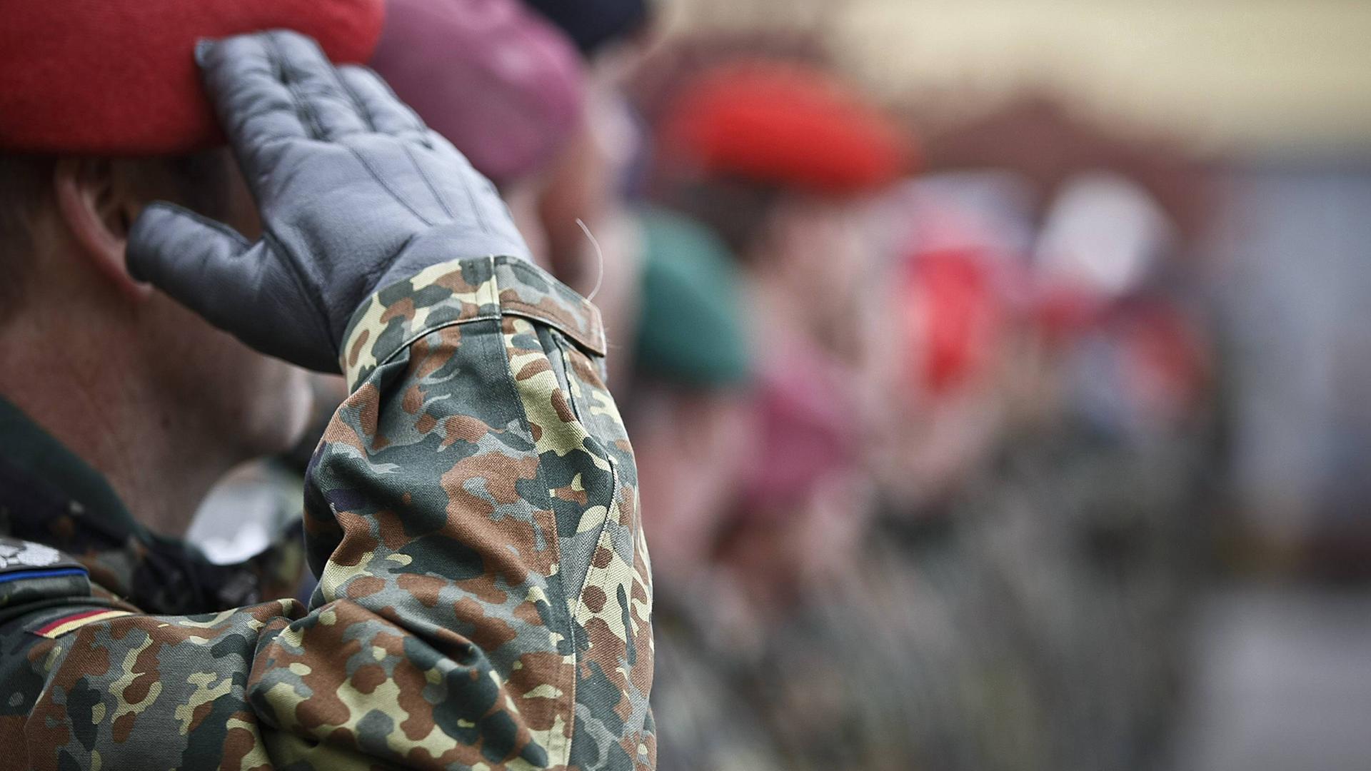 Soldat von der Seite, der die Hand zum Gruß hebt.