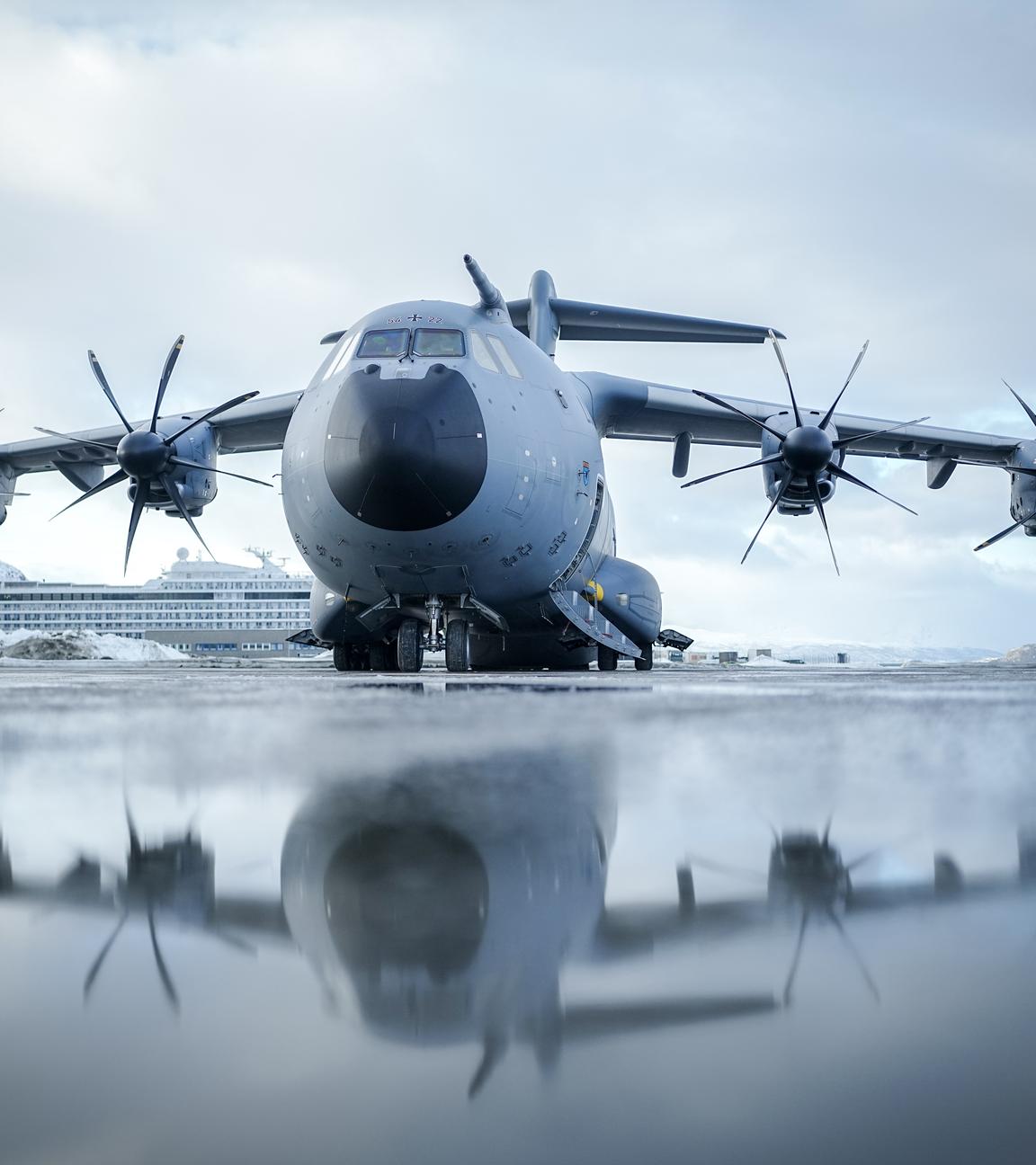 Der Airbus A400M der Luftwaffe steht vor dem Start nach Helsinki vor einem Kreuzfahrtschiff am Flughafen in Alta.