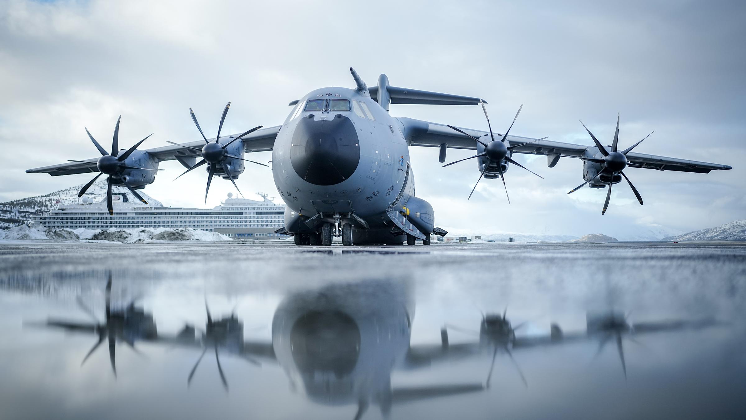 Der Airbus A400M der Luftwaffe steht vor dem Start nach Helsinki vor einem Kreuzfahrtschiff am Flughafen in Alta.