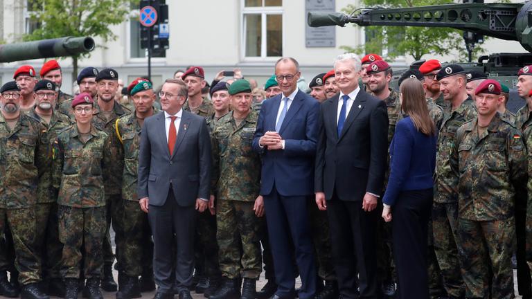 German Defence Minister Boris Pistorius, German Chancellor Friedrich Merz, Lithuanian President Gitanas Nauseda and Lithuanian Defence Minister Dovile Sakaliene pose for a group photograph with German servicemen and servicewomen after the inauguration of the German 45th Armoured Brigade 'Lithuania', at the Cathedral Square in Vilnius