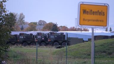 Weißenfels, Sachsen-Anhalt: Das Ortsschild von Weißenfels, im Hintergrund Fahrzeuge der Bundeswehr.