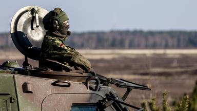 Bundeswehr-Soldatin blickt oben aus einem Panzer.
