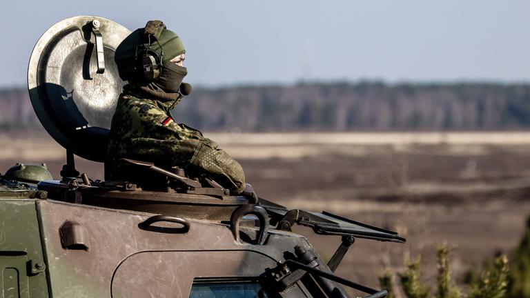 Bundeswehr-Soldatin blickt oben aus einem Panzer.